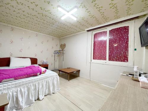 a bedroom with a bed and a window at Seven Motel in Busan