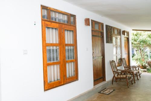 Anu Villa Wadduwa في وادوا: شرفة مع كراسي وباب خشبي