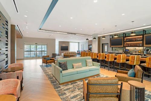 a lobby with a couch and a bar at Cambria Hotel Fort Worth - Medical Center in Fort Worth