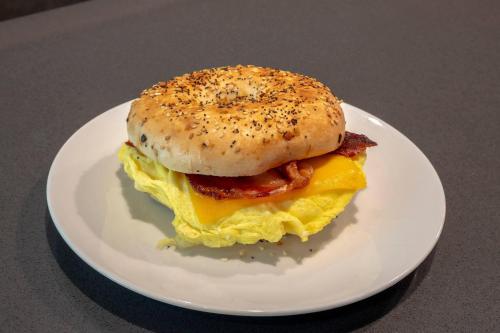Un sándwich de bagel para el desayuno en un plato blanco en Cambria Hotel Fort Worth - Medical Center, en Fort Worth