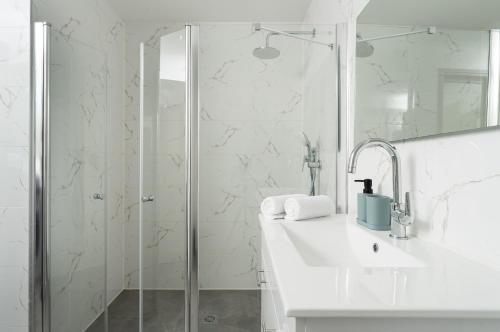 a white bathroom with a sink and a shower at DreamyRent Aqua Sol Eilat in Eilat