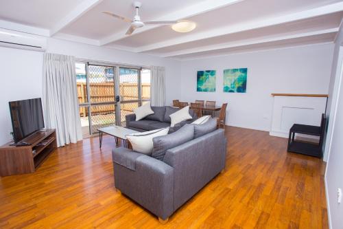 a living room with a couch and a tv at Wilsonton Hotel Toowoomba in Toowoomba