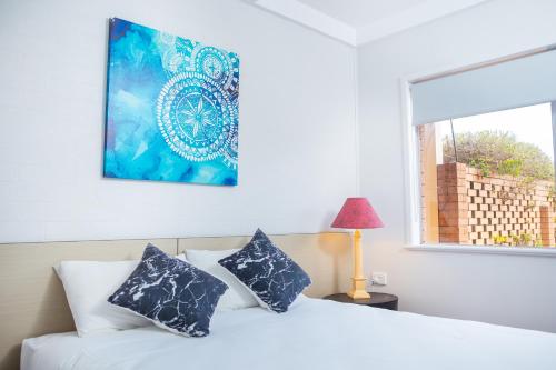 a bedroom with a white bed with blue pillows at Wilsonton Hotel Toowoomba in Toowoomba