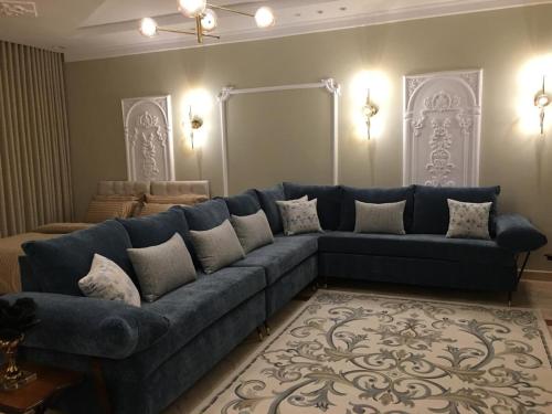 a large blue couch in a living room at Big studio apartment in Makkah