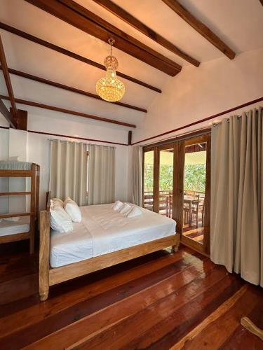 a bedroom with a bed and a large window at Tirso and Nora's Inn in General Luna