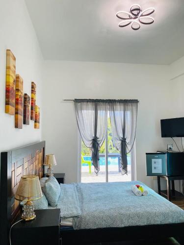 a bedroom with a bed and a window with a patio at Couple room A in Final Destination Resort in Bolinao
