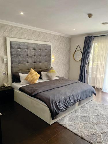 a bedroom with a large bed with a large headboard at The Executive Suite in Lagos