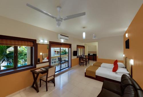 a hotel room with a bed and a living room at Sandalwood Hotel & Suites in Panaji