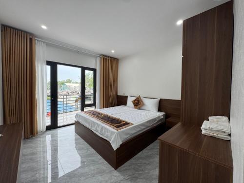 een hotelkamer met een bed en een balkon bij Vạn Xuân Royal Hotel in La Phù