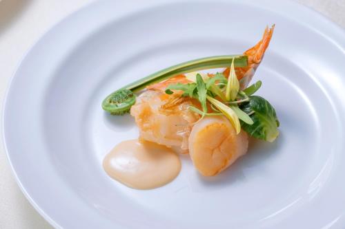 一棟貸しゲストハウス マリドール في إزومو: طبق من الطعام عليه روبيان وخضروات