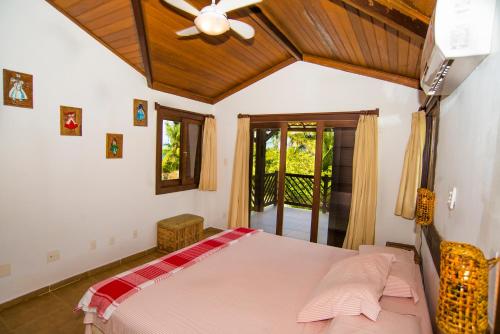 a bedroom with a bed and a ceiling fan at Casa Edy in Praia do Forte