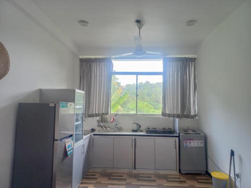a kitchen with a sink and a window and a refrigerator at Relax inn modara in Mirissa