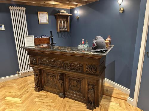 a large wooden bar in a room with a blue wall at Crippens, Quintissential Luxury Central, Parking & EV in Canterbury