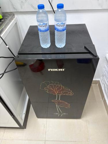 two bottles of water sitting on top of a refrigerator at Sea Side Studio in Abu Dhabi