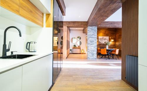 a kitchen with white cabinets and a dining room at NEO Skyview Suites in Gudauri