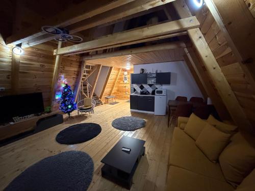 una sala de estar con un árbol de Navidad en una cabaña en Colț de RAI A-Frame, en Drumu Carului