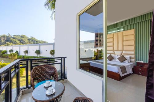 een slaapkamer met een bed en een tafel op een balkon bij Nature Trails Chilla, Rishikesh in Rāiwāla