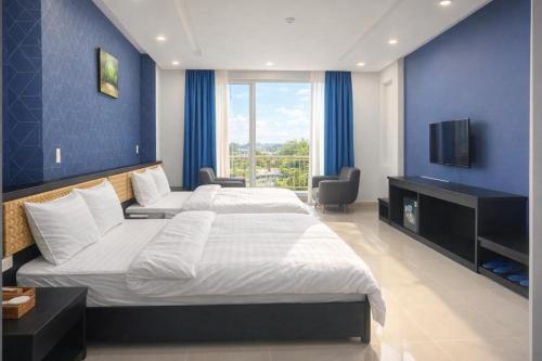 a bedroom with two beds and a flat screen tv at Hưng Phú Hotel HCM in Ho Chi Minh City