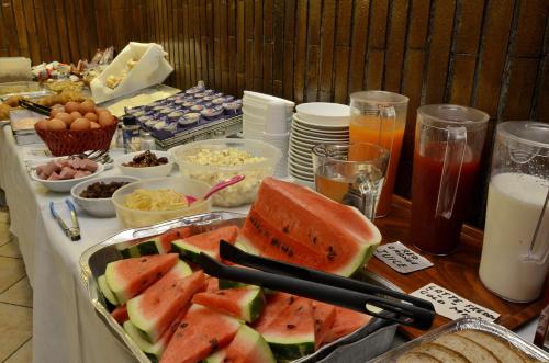 Una mesa con una bandeja de sándwiches de sandía y otros alimentos. en Hotel Tirreno, en Roma