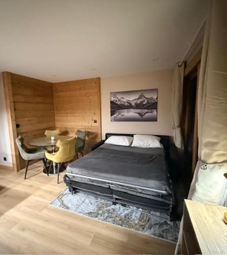 a bedroom with a bed and a table in it at Le 1954 La Rosière in La Rosière