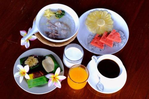 a table with plates of food and a cup of coffee at Garto Beach Resort Samui in Ban Thong Phlu