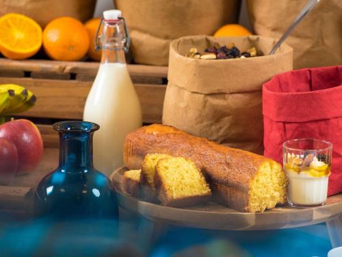 Una bandeja con pan y una botella de leche y naranjas. en ibis budget Genève Aéroport, en Ginebra
