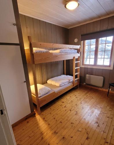 two bunk beds in a room with a wooden floor at Øen Turistsenter Cottages in Geilo