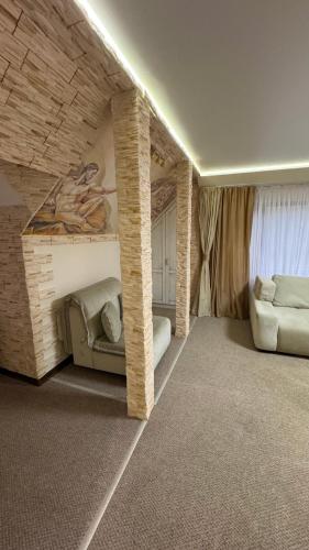 a living room with two couches and a brick wall at Чумацький табір in Dryglov