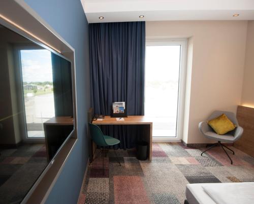 a hotel room with a desk and a window at BEST WESTERN Hotel The K Unterföhring in Munich