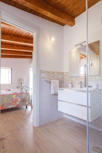a white bathroom with a sink and a bed at Al Quindici in Gaeta