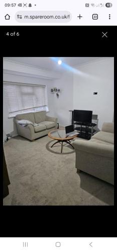 a living room with two couches and a piano at 14 london road in Stonewood