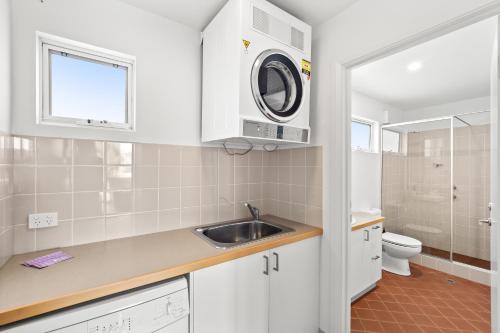 una cocina con fregadero y lavadora en The Surf Nook - Walk to Beach - Family Friendly, en Gracetown