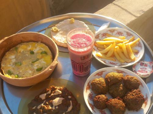 a table topped with plates of food and a drink at Hashem Nubian Guest House in Aswan