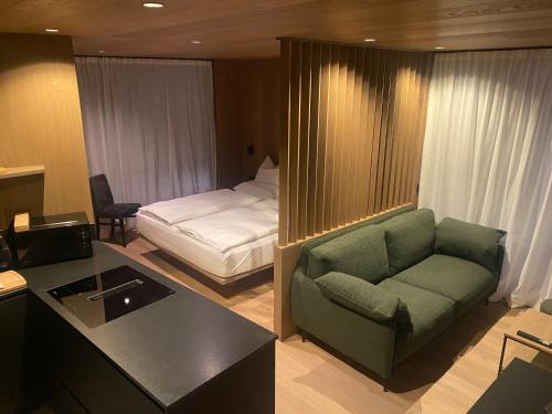 een hotelkamer met een bank en een bed bij Residence Cesa Callegari in Selva di Val Gardena