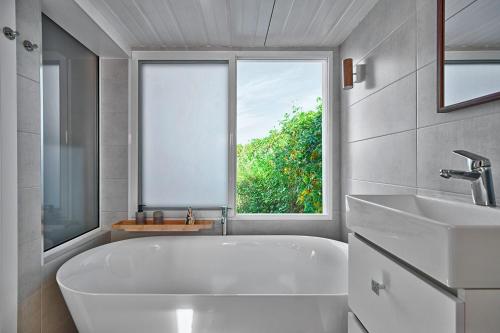 a bathroom with a large white tub and a window at Casa Boletes, with splendid views! in Cartagena
