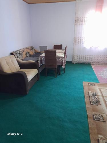 un soggiorno con un divano e un tappeto verde di Guest House a Xınalıq