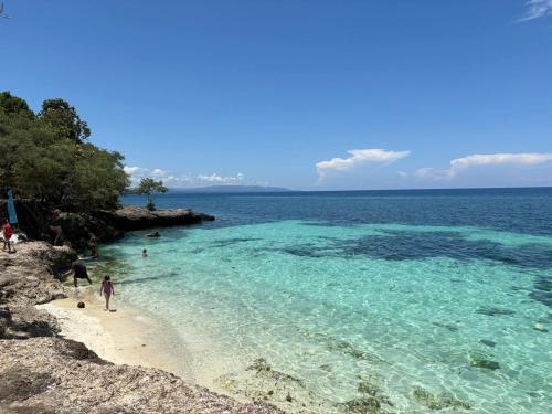 Villa Izabella in Panglao Island في داويس: مجموعة من الناس على شاطئ في المحيط