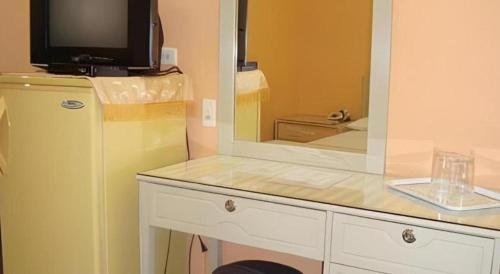 uma cozinha com um balcão com um espelho e um frigorífico em Cebu Northwinds Hotel em Cebu