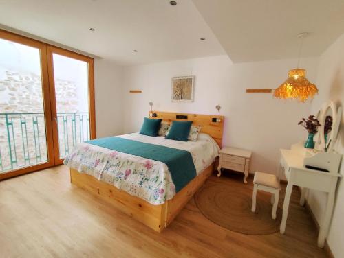 ein Schlafzimmer mit Bett, Schreibtisch und Fenster in der Unterkunft Casas del Castillo Peñíscola-Intramuros Suites in Peñíscola