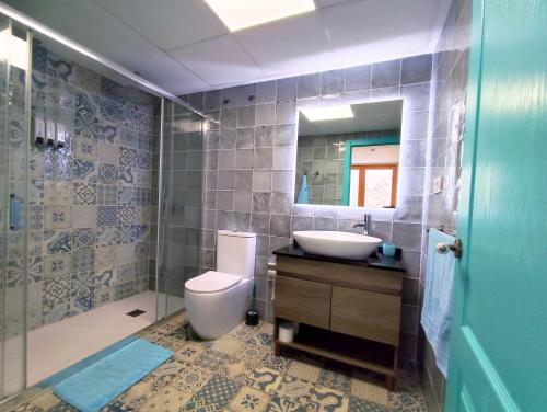 ein Badezimmer mit Toilette, Waschbecken und Dusche in der Unterkunft Casas del Castillo Peñíscola-Intramuros Suites in Peñíscola