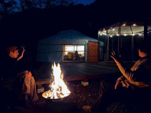 a group of people sitting around a fire at みどりの村 in Ogano