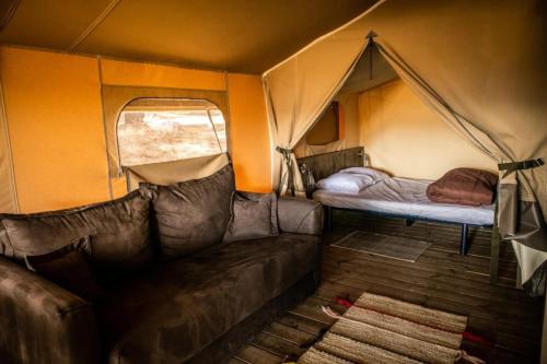 a living room with a couch in a tent at Camping 3 étoiles - Piscine - ccbccbe in Sartène