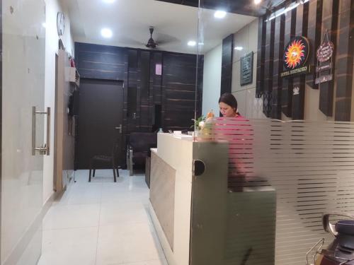 uma mulher sentada num balcão num restaurante em Hotel Suryadeo em Jabalpur