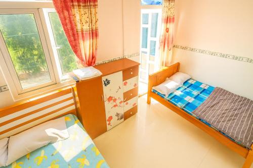 a small room with two beds and a window at Ngọc Mơ Motel in Ho Chi Minh City