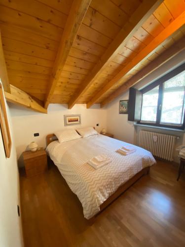 a large bed in a room with a wooden ceiling at Mansarda Residenza Giada in Pila