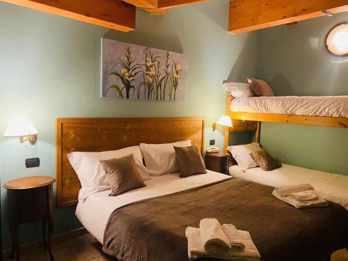 two beds in a room with two bunk beds at Hotel Lion in Roure Turin