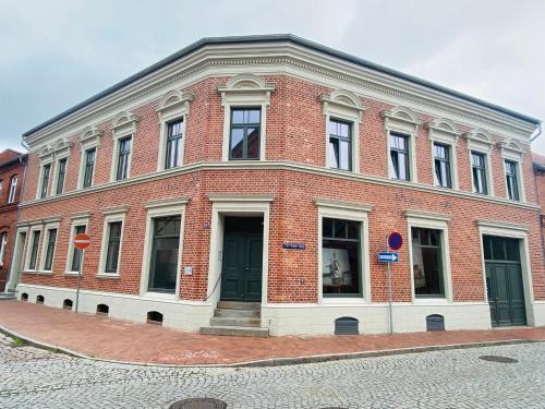 un grand bâtiment en briques dans une rue de la ville dans l'établissement der Elbe so nah, à Dömitz