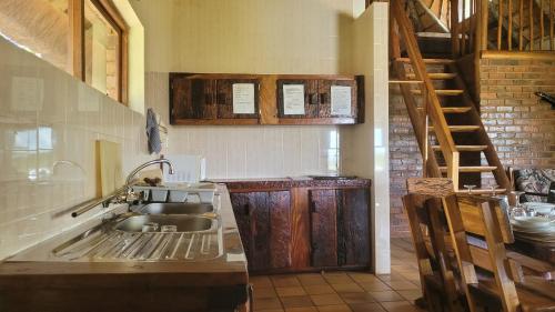 a kitchen with a sink and a staircase at Lush Horizons Game Lodge in Modimolle