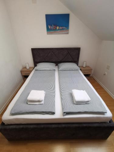 ein Bett in einem Zimmer mit zwei Handtüchern darauf in der Unterkunft Apartman Batuda,moderno opremljen apartman u centru Đurđevca, u cijeni WELLNESS, sauna, bazen u obližnjem hotelu, mini zoo, 5G internet, R1 račun, SELF CHECKIN, WELLNESS NO AVAILABLE 1 8-15 8 in Ðurđevac