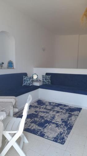 ein Zimmer mit einer Bank, einem Stuhl und einem Teppich in der Unterkunft Aichoucha suite in Fafou